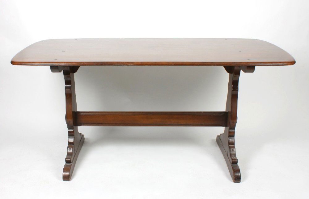An Ercol oak refectory style dining room table: An Ercol oak refectory style dining room table. The shaped rectangular top with rounded edge above a base with shaped panel ends united by a single stretcher. 60" (152.5cm) length, 30" (76.25cm) width
