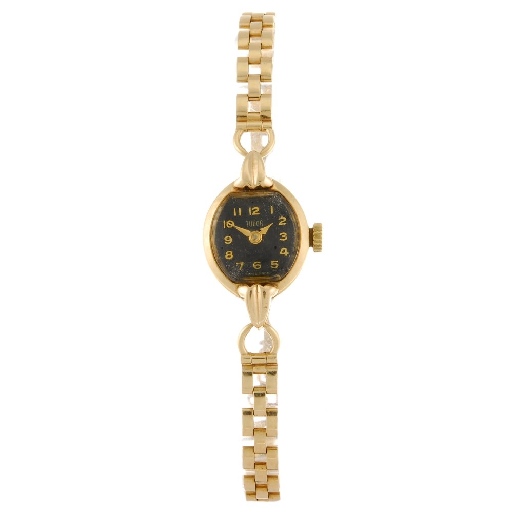A 9ct gold manual wind lady's Tudor bracelet watch.: TUDOR - a 9ct gold manual wind lady's bracelet watch, the black dial with Arabic numerals, oval shaped case fitted to an integral 9ct gold bracelet with clasp, signed movement. Case width 14mm. Total 