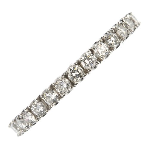 A diamond eternity ring.: A diamond eternity ring. The brilliant-cut diamonds, to the plain band. Estimated total diamond weight 0.75ct. Weight 3.5gms.