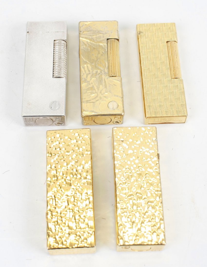 DUNHILL - five assorted lighters: DUNHILL - five assorted lighters. Comprising four gold plated - two with bark effect, one with chequered engine turning and one textured - plus one silver-plated, all 2.5", (6.5cm), (5).