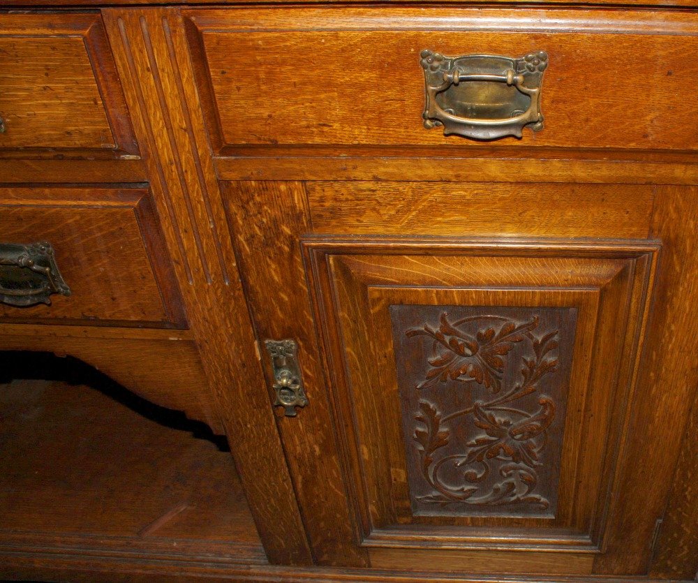 A late Victorian/Edwardian carved light oak sideboard