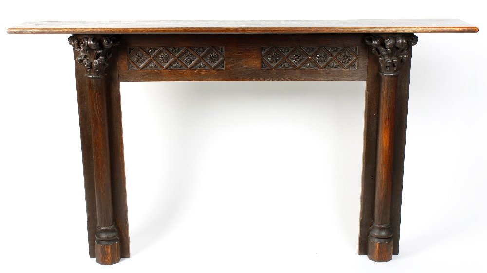 An early 20th century gothic revival oak fire surround