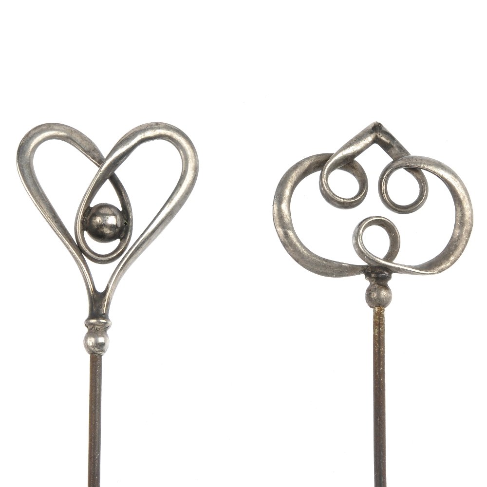 Charles Horner - two early 20th century silver hat pins: CHARLES HORNER - two early 20th century silver hat pins, each with entwined openwork terminal. Hallmarks for Chester, 1908. Lengths 23 to 14.6cms.
