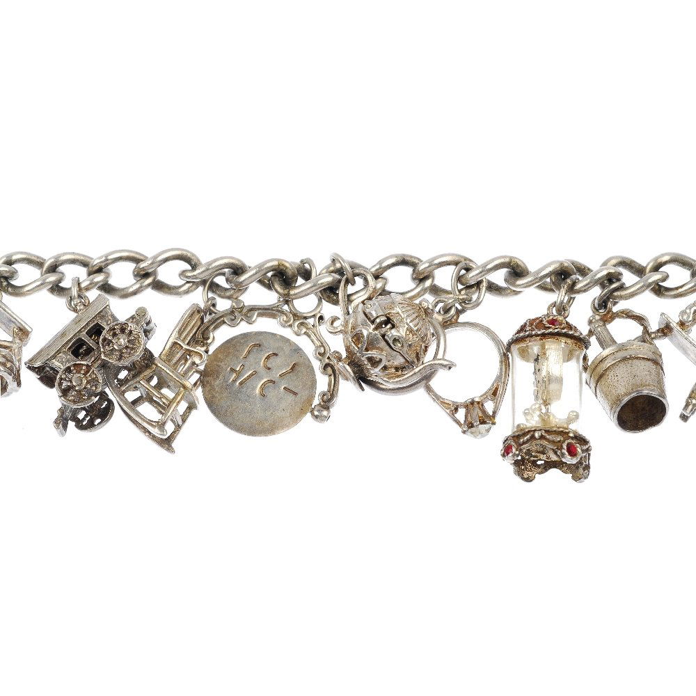 A selection of three silver and white metal charm: A selection of three silver and white metal charm bracelets. Comprising a total of thirty-nine charms, to include an enamel cockerel, an elephant and a rocking chair, suspended from three curb-link ch