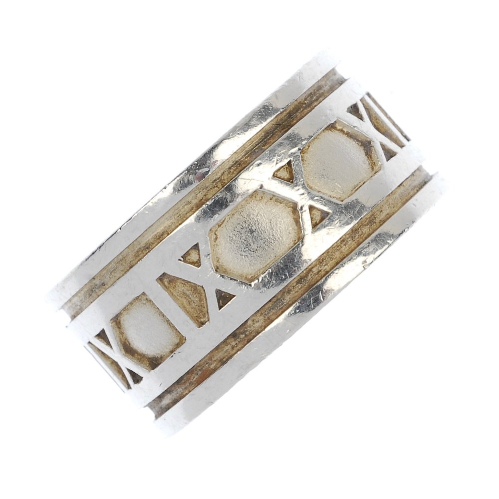 TIFFANY & CO. - an 'Atlas' ring.: TIFFANY & CO. - an 'Atlas' ring. The wide band with central Roman numeral motif, to the grooved border. Signed Tiffany & Co. Width 1.2cms. Ring size T. Weight 15.1gms.