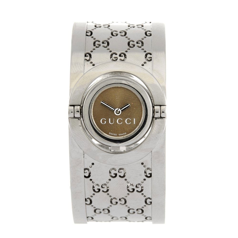 A stainless steel quartz lady's Gucci Twirl bangle: GUCCI - a stainless steel quartz lady's Twirl bangle watch, the bronze coloured dial set within a rotating case, fitted to a steel trellis pattern bangle with clasp. Bangle width 22mm.