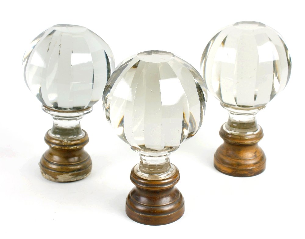 A set of three large early 20th century clear glass doo: A set of three large early 20th century, clear glass door knobs of facetted globular twelve sided form, terminating in gilt metal collars. 4.5" (11.5cm) diameter x 7.75" (19.5cm) long.
