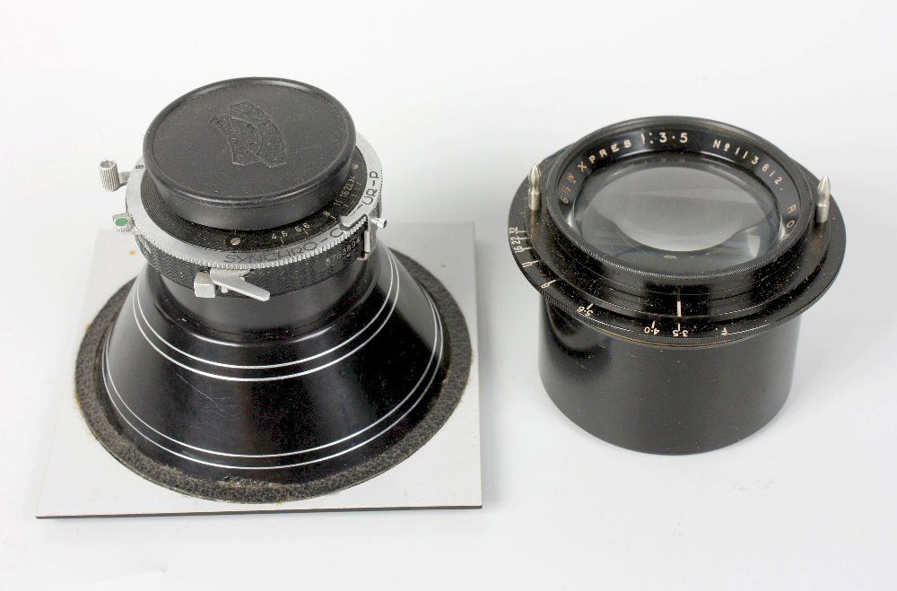 A selection of vintage photographic lenses, wooden and : An old leather suitcase containing a mixed selection of vintage photographic lenses, wooden and metal plate slides, a 1930's Thornton Pickard catalogue, a 1934 Zeiss Ikon catalogue and three vintage t