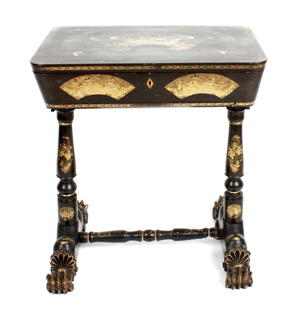 A 19th century lady's black lacquered work/sewing table: A 19th century lady's black lacquered work/sewing table, the hinged top opening to reveal a compartmented and fitted interior, the whole with applied gilt chinoiserie decoration, the underside of the 