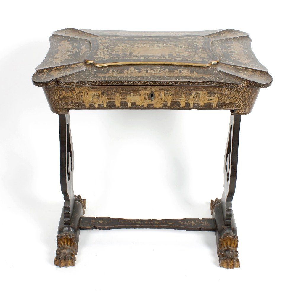 A 19th century lady's black lacquered ladies work/sewin: A 19th century lady's black lacquered work/sewing table, the hinged shaped top opening to reveal a compartmented and fitted interior, the whole with applied gilt chinoiserie decoration, the lyre shape