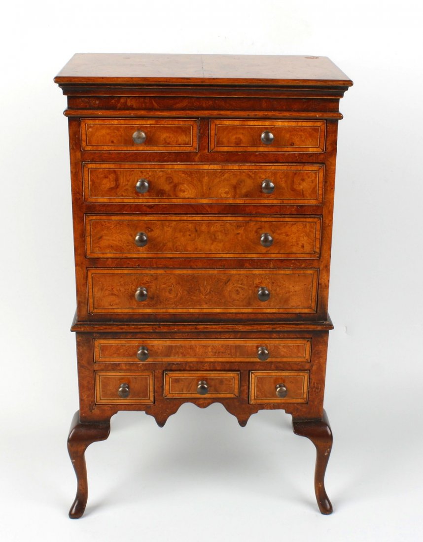 A good early 20th century walnut veneered miniature che: A good early 20th century walnut veneered miniature chest on stand, the moulded cornice above two short and three long graduated drawers, the base section with one long and three small drawers, the wh
