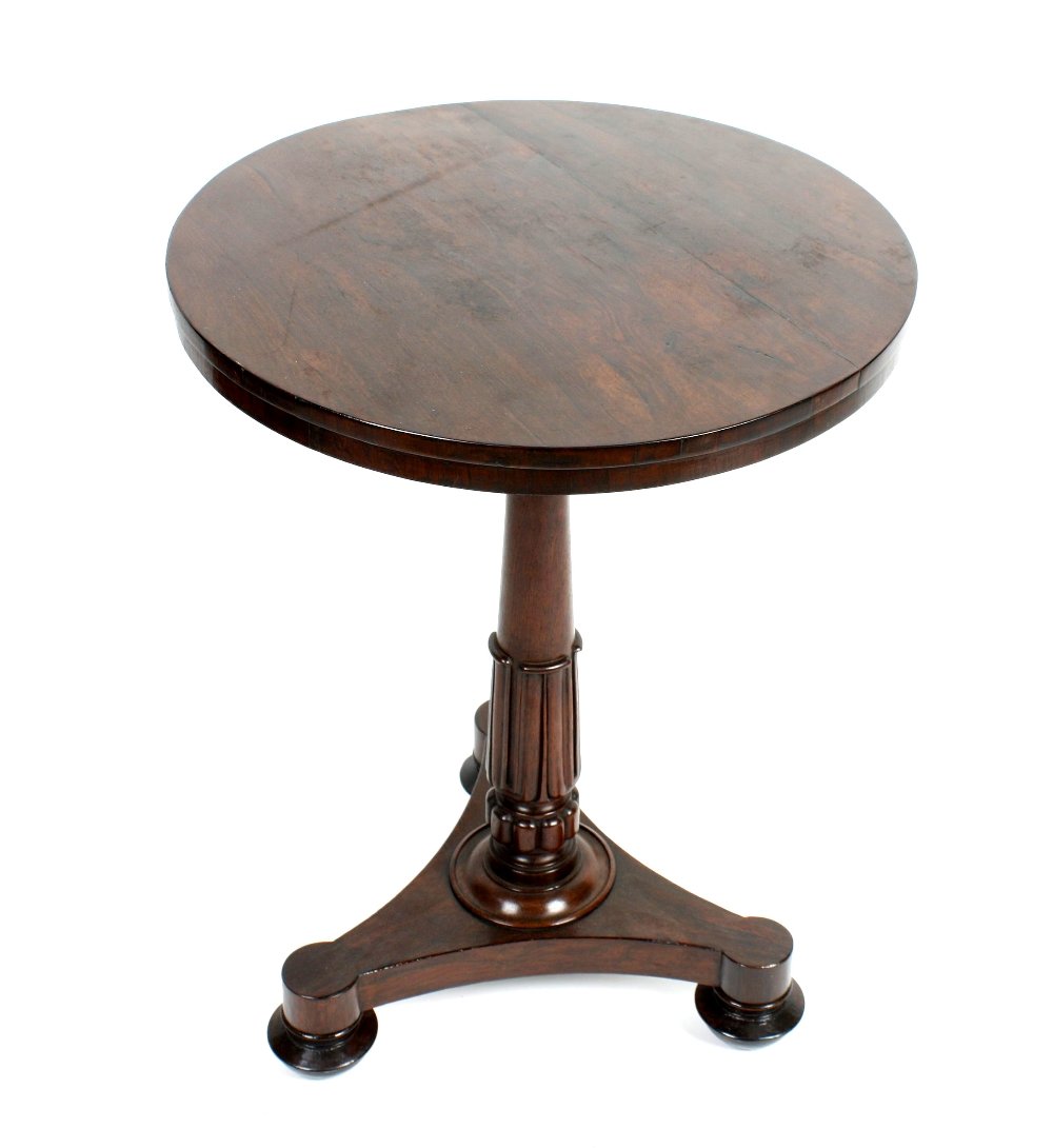 A 19th century rosewood occasional table: A 19th century rosewood occasional table, the plain circular top above a carved, turned and tapered column, the shaped platform base upon three bun feet. 21.25" diameter x 28.5" high, (54cm x 72.5cm).