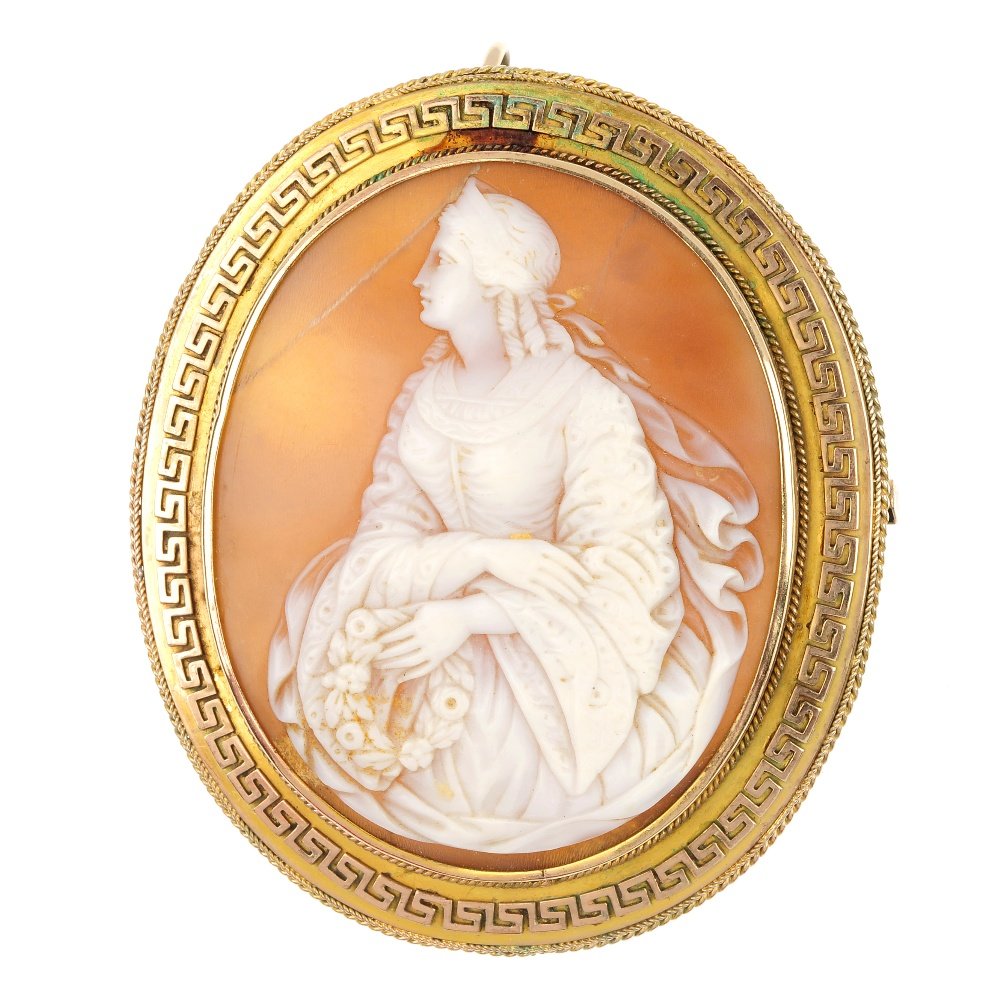 A late 19th century shell cameo brooch.: A late 19th century shell cameo brooch, of oval-shape outline, the shell cameo carved to depict a classical lady holding a wreath, within a Greek Key and rope-twist surround. Length 6cms.
