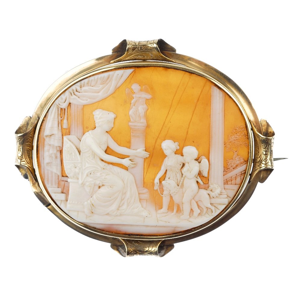 A shell cameo brooch.: A shell cameo brooch, of oval outline, the shell cameo depicting a mother and two children with a dog, to the engraved scroll detail surround. Length 7.1cms.