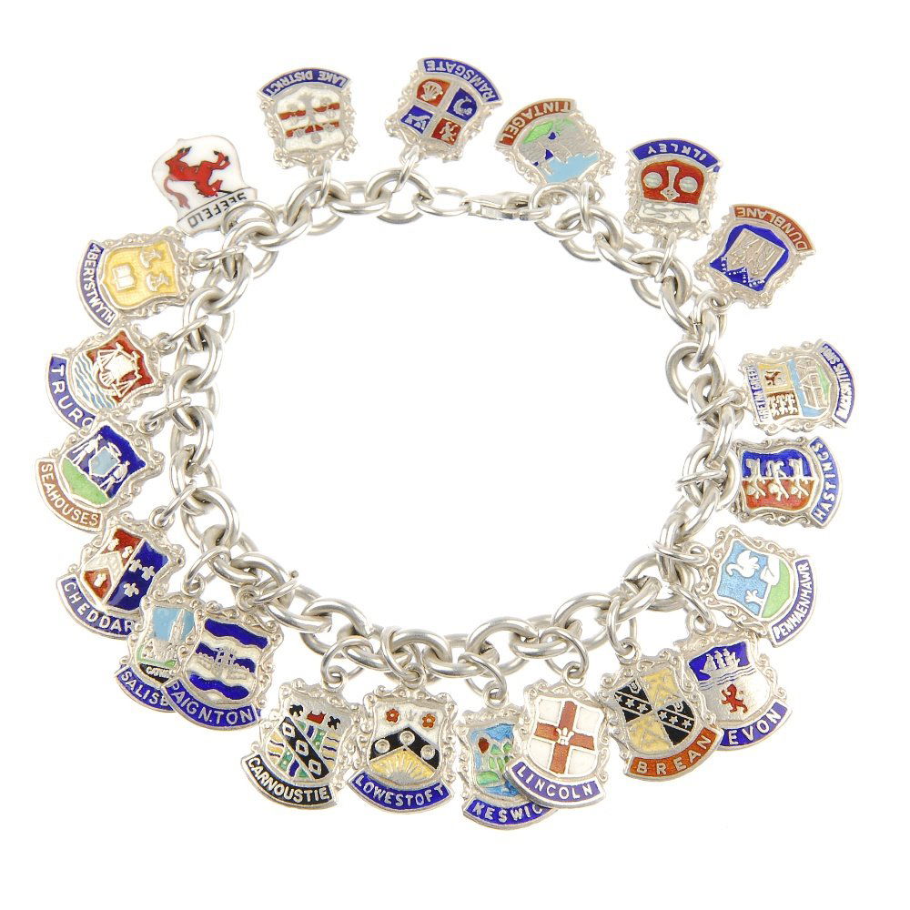 Two charm bracelets and three charms on a chain.: Two charms bracelets, suspending forty-three charms, together with a chain suspending a compass charm, an enamel Egyptian revival sarcophagus pencil, together with an enamel Egyptian revival head in p