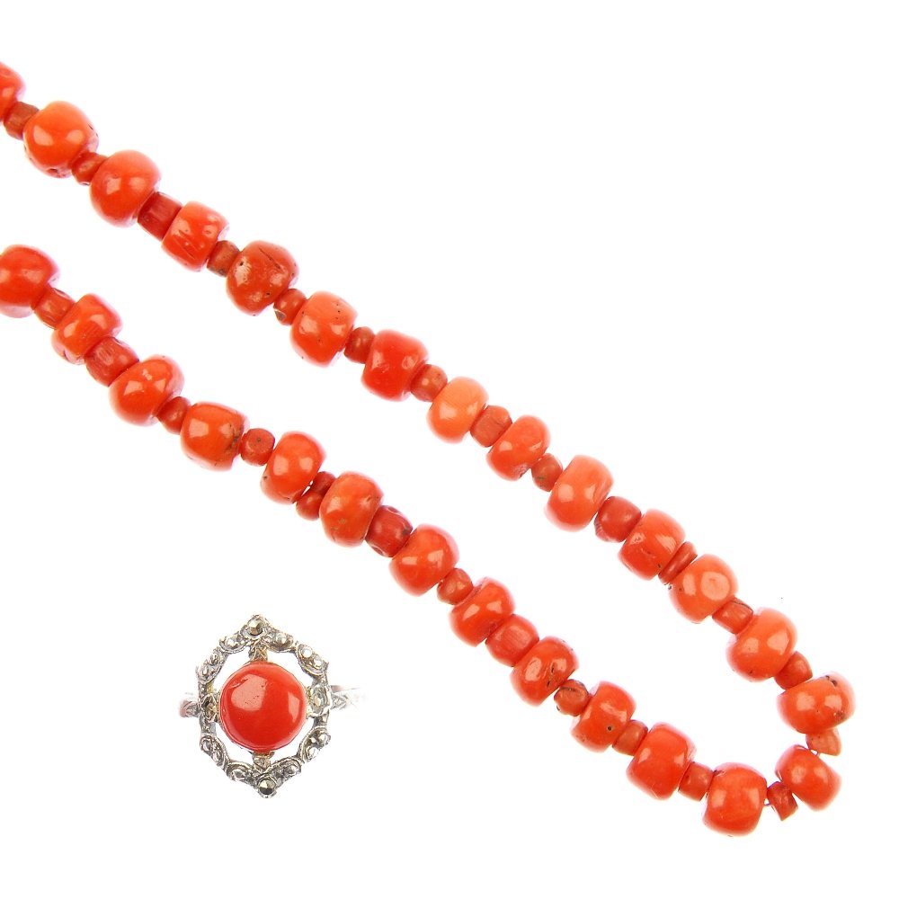 A coral bead necklace and a coral ring.: A coral bead necklace and a coral ring, the necklace designed as a series of coral beads with smaller coral bead intervals, together with a circular coral cabochon and marcasite cluster ring. Coral un