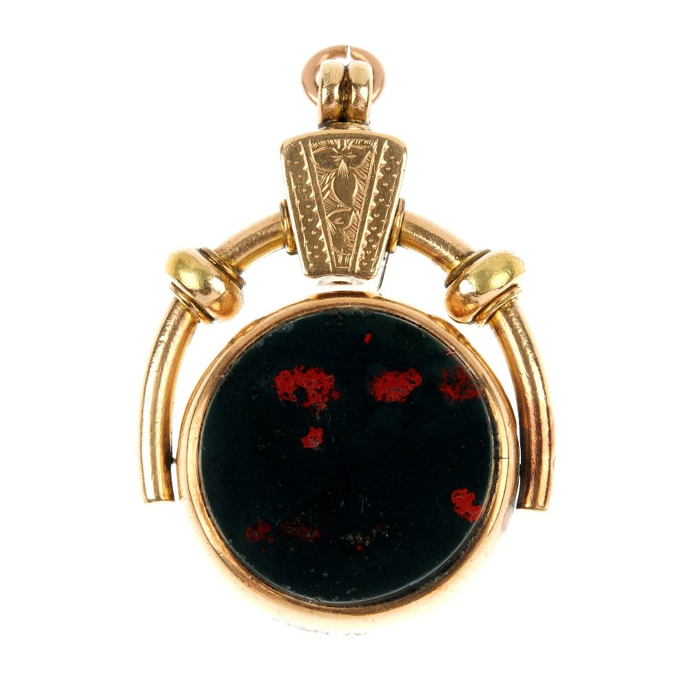 A late 19th century hardstone swivel fob.: A late 19th century hardstone swivel fob. The circular-shape carnelian and bloodstone rotating panel, to the scroll and floral engraved surmount. Length 4.1cms.