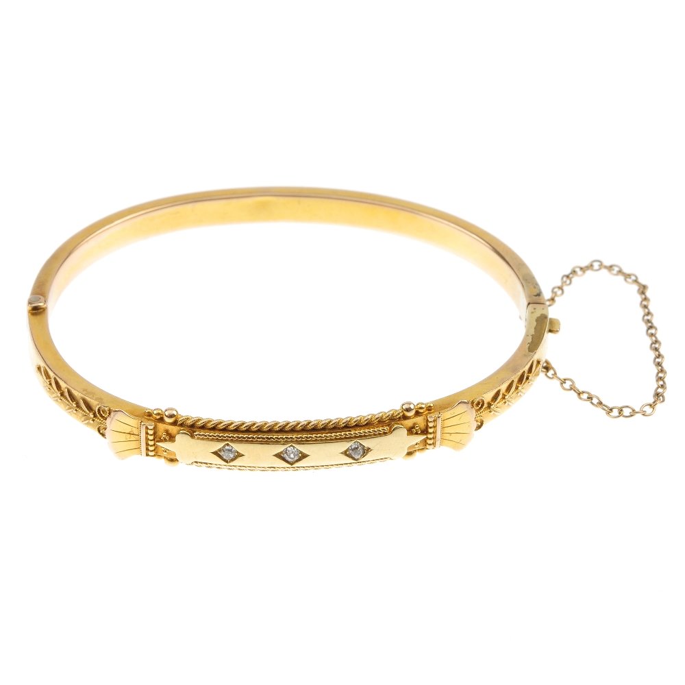 A late 19th century 15ct gold diamond bangle.: A late 19th century 15ct gold diamond bangle. The front designed as a series of three old-cut diamonds, within a rope-twist surround, to the stylised shell and filigree shoulders and plain half bangle