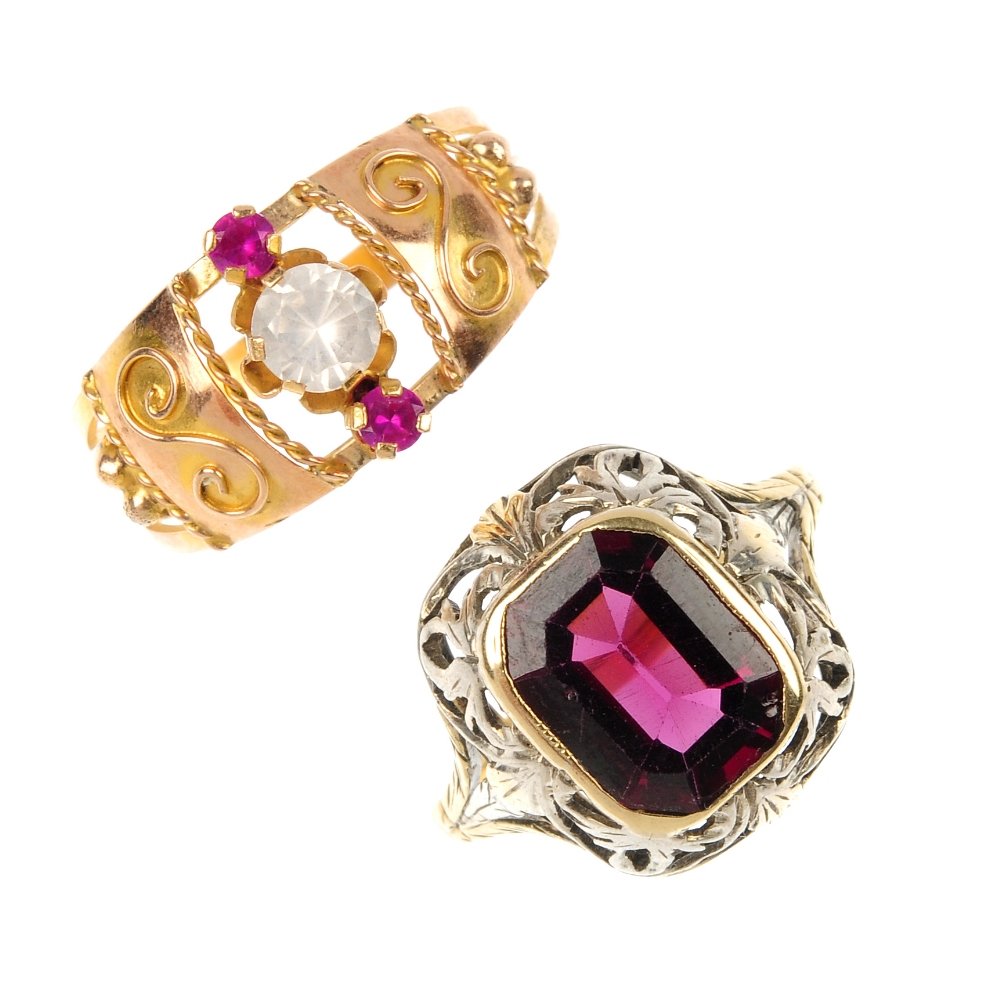 Two gem-set rings.: Two gem-set rings. The first designed as a rectangular-shape garnet, within an openwork scrolling surround, the second set with a synthetic ruby and colourless paste line. Weight 5.2gms.