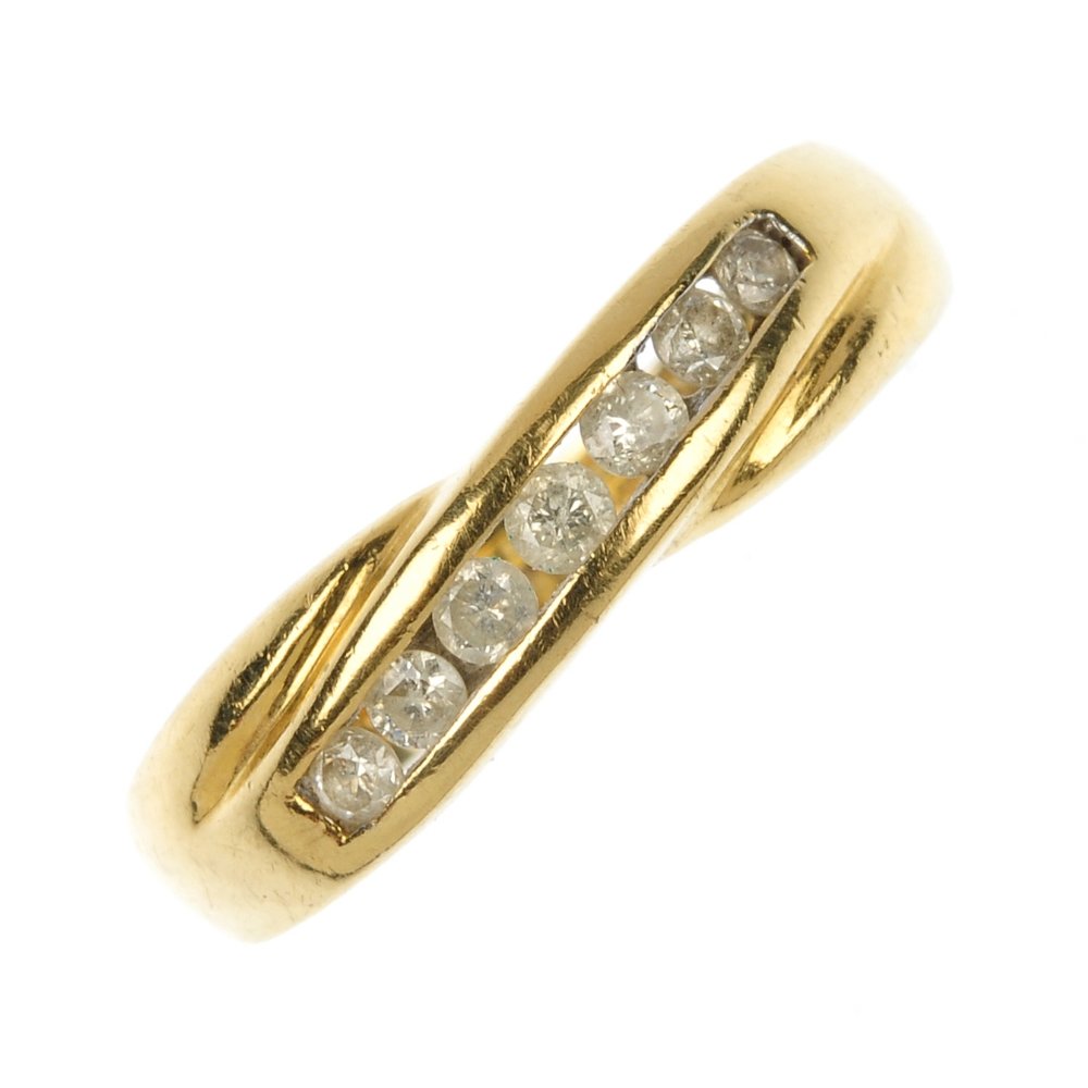 An 18ct gold diamond half-circle eternity ring.: An 18ct gold diamond half-circle eternity ring. The brilliant-cut diamond channel-set line, to the crossover band. Total diamond weight 0.25ct, stamped to band. Hallmarks for Sheffield. Weight 3.9gms.
