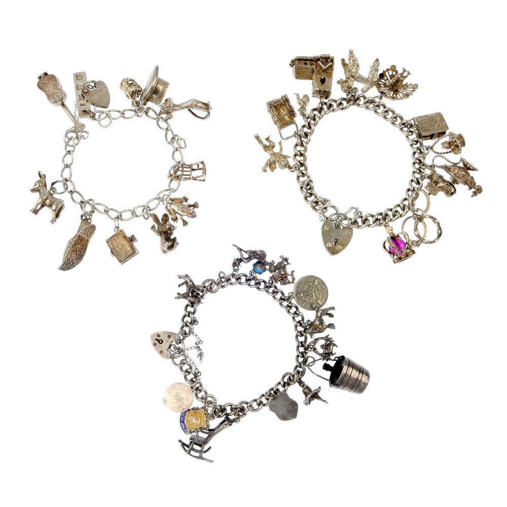 A selection of three charm bracelets.: A selection of three charm bracelets. The silver curb and elongated curb-link bracelets, suspending a total of thirty-six charms, to include a frog, a poodle and a treasure chest, to the heart-shape p