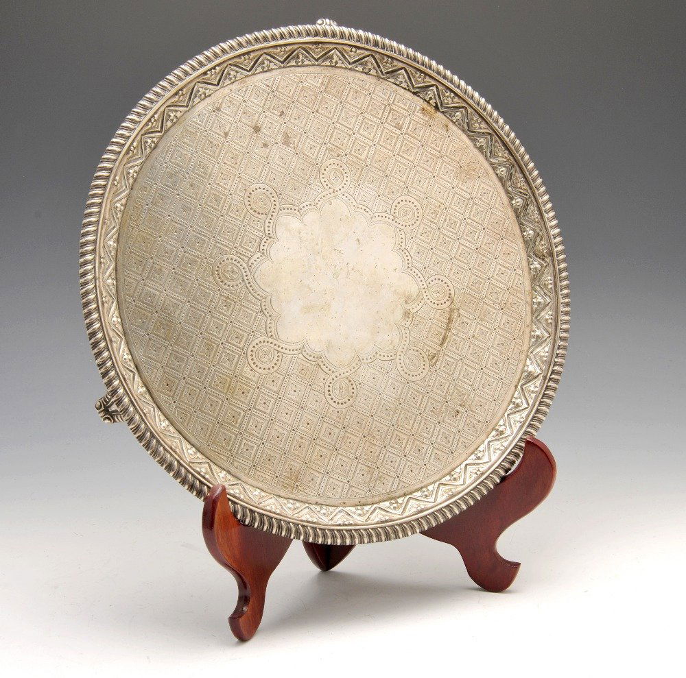 A George III silver salver.: A George III silver salver of circular form, the central vacant cartouche with diaper surround and raised edge to the gadrooned rim and above three bracket feet. Hallmarked Solomon Hougham, London 181