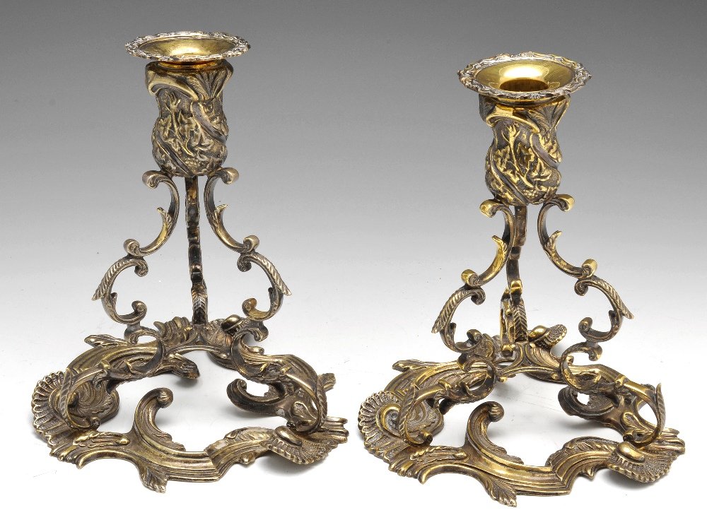A modern pair of Irish silver gilt candleholders.: A modern pair of Irish silver-gilt candlesticks in Rococo style, each with a foliate shell moulded pierced base rising to three scrolled supports and a leaf embossed socket with removable nozzle. Hall