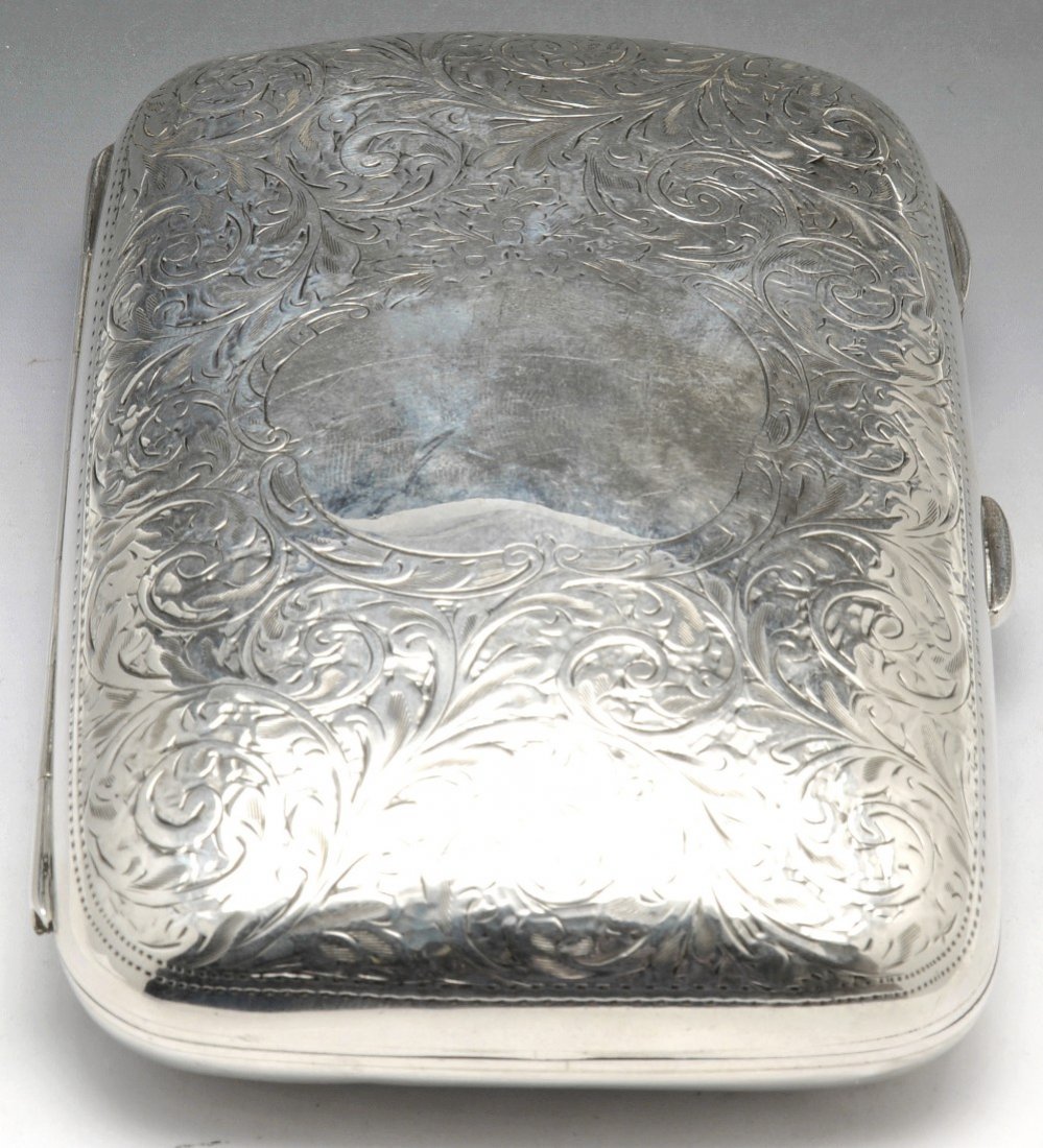 An Edwardian silver cigar case.: An Edwardian silver cigar case, of curved rectangular form, the foliate engraved body, with plain cartouche. Hallmarked H V Pithey & Co, Chester 1907. Length 4 3/4 inches (12 cm). Weight 4.26 ozt (132