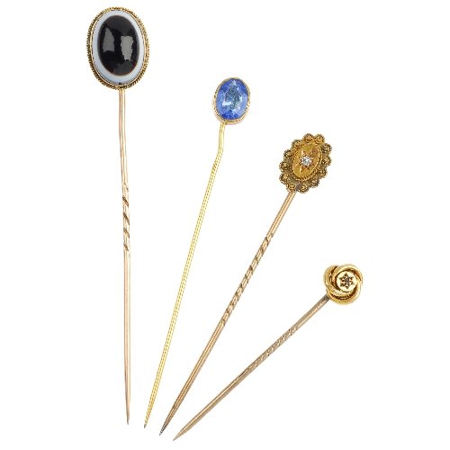 A selection of four stickpins.: A selection of four stickpins, to include two late Victorian 15ct gold diamond set stickpins, an oval onyx cabochon and an oval blue paste. Lengths 7.5 to 4.5cms. Total weight 6.7gms.