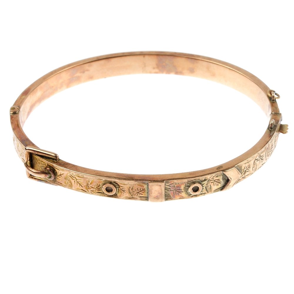 An early 20th century 9ct gold hinged bangle.: An early 20th century 9ct gold hinged bangle. The front designed as a buckle, to the plain half-bangle. Hallmarks for Birmingham, 1900. Inner diameter 5.8cms. Weight 7.7gms.