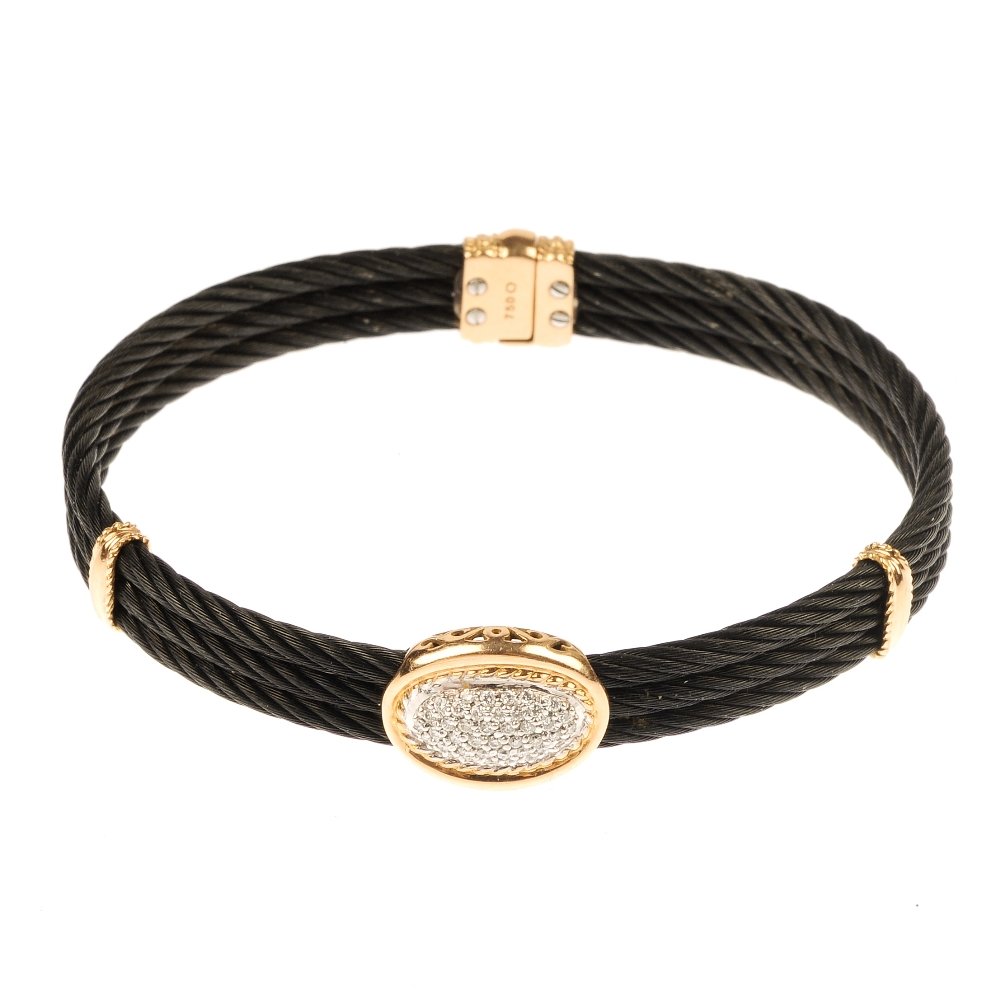 CHARRIOL - a 'Celtic Noir' diamond bangle.: CHARRIOL - a 'Celtic Noir' diamond bangle. Designed as a series of three rows of black pvd steel cables, with central brilliant-cut diamond oval-shape cluster. Signed Charriol. Estimated total diamond