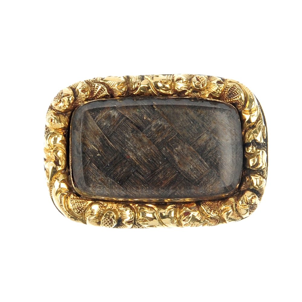 A late 19th century mourning brooch.: A late 19th century mourning brooch. Of rectangular-shape outline, the woven hair panel, within a scroll embossed surround. Length 2cms.