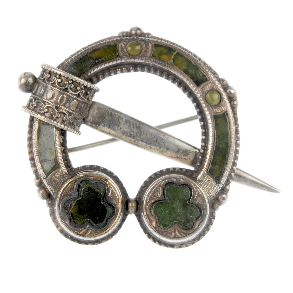A late 19th century silver Scottish brooch.: A late 19th century silver Scottish brooch, the tara style brooch inlaid with green hard stone. Length 3.6cms. Weight 10.5gms.