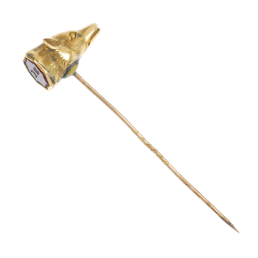 An early 20th century fox head seal stickpin.: An early 20th century fox head seal stickpin, the fox head terminal backed with an octagonal carnelian intaglio seal with initials UE, to the later added pin. Length of terminal 2.2cms. Length of pin