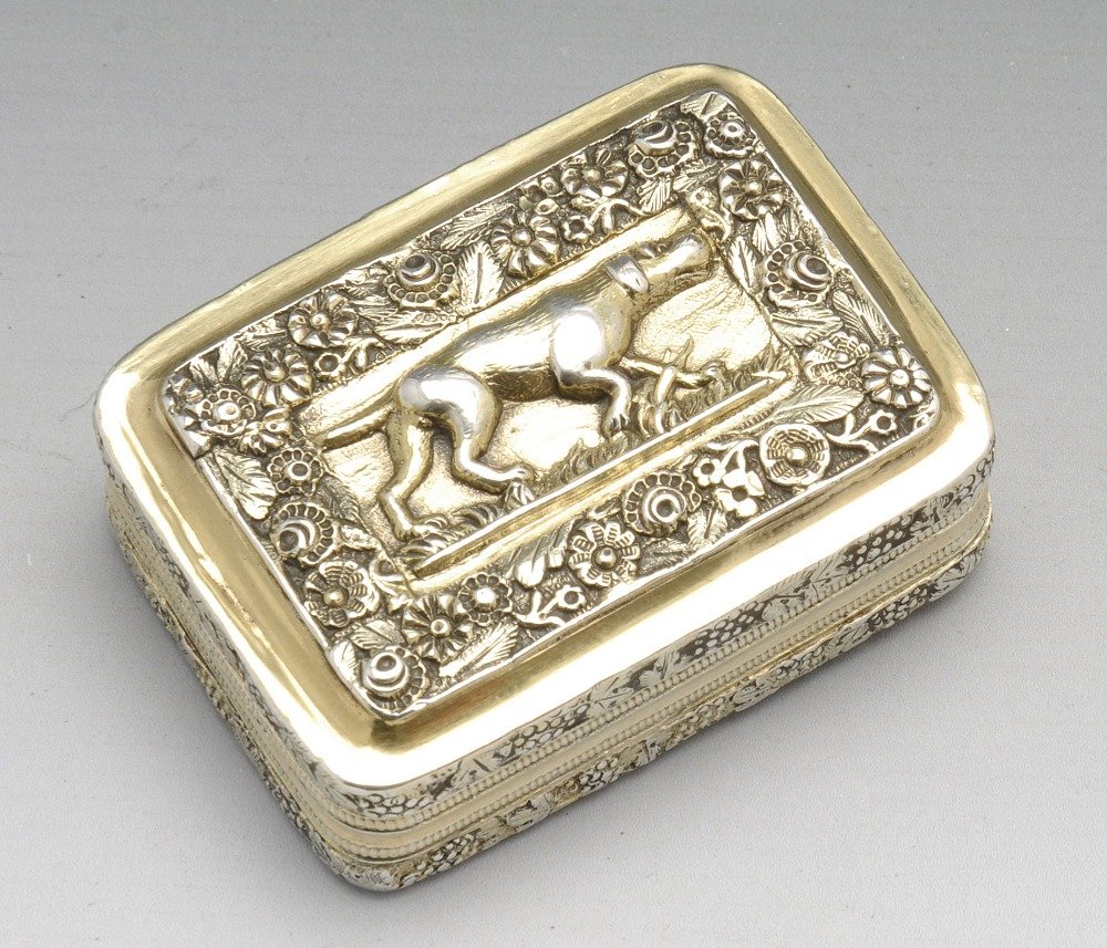 A late George III silver gilt vinaigrette.: A late George III silver-gilt vinaigrette, the lid embossed with pointer dog and floral surround, to the grape and vine sides and engine turned base, opening to reveal a scrolling floral pierced grill