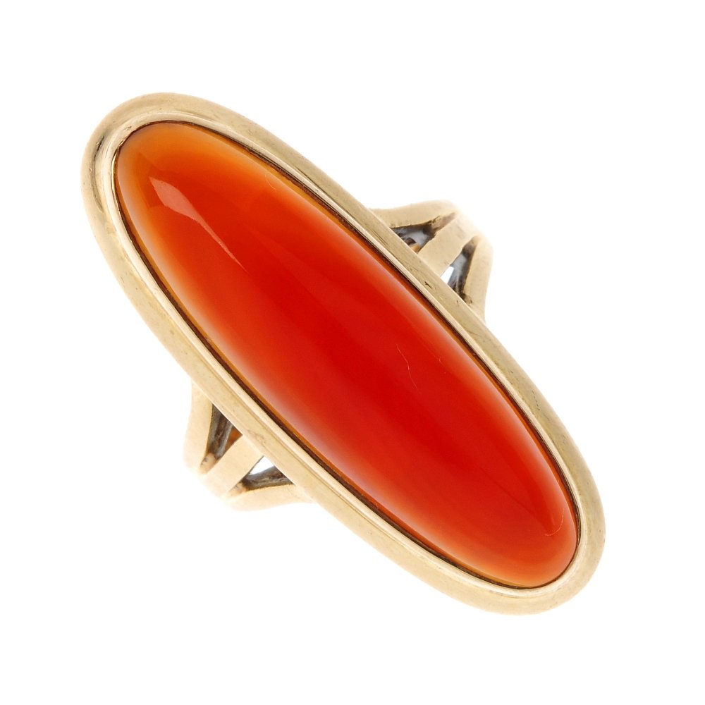 A carnelian single-stone ring.: A carnelian single-stone ring. The oval carnelian cabochon, within a collet surround, to the bifurcated shoulders. Weight 7.9gms.