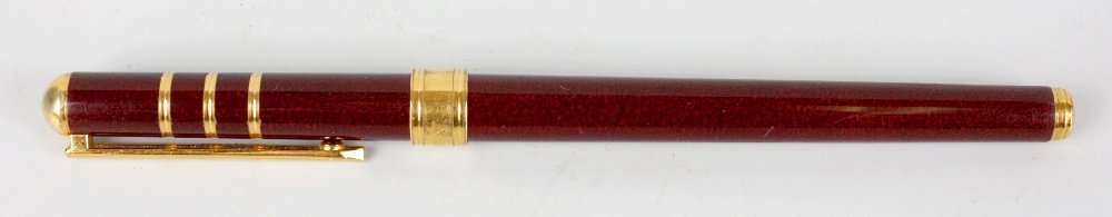 An Yves Saint Laurent fountain pen.: An Yves Saint Laurent fountain pen. The wine resin body with nib stamped YSL, 5.5", (14cm) long.