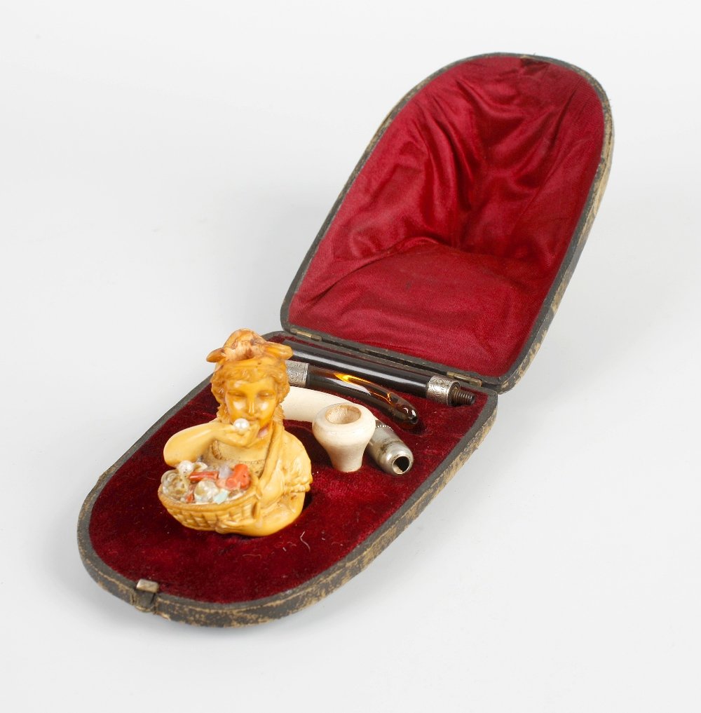 An unusual late 19th century carved meerschaum cheroot : An unusual late 19th century carved meerschaum cheroot holder in fitted case. The holder modelled as a young lady pedlar, with a basket of shells, coral, pearls and turquoise suspended from her neck,
