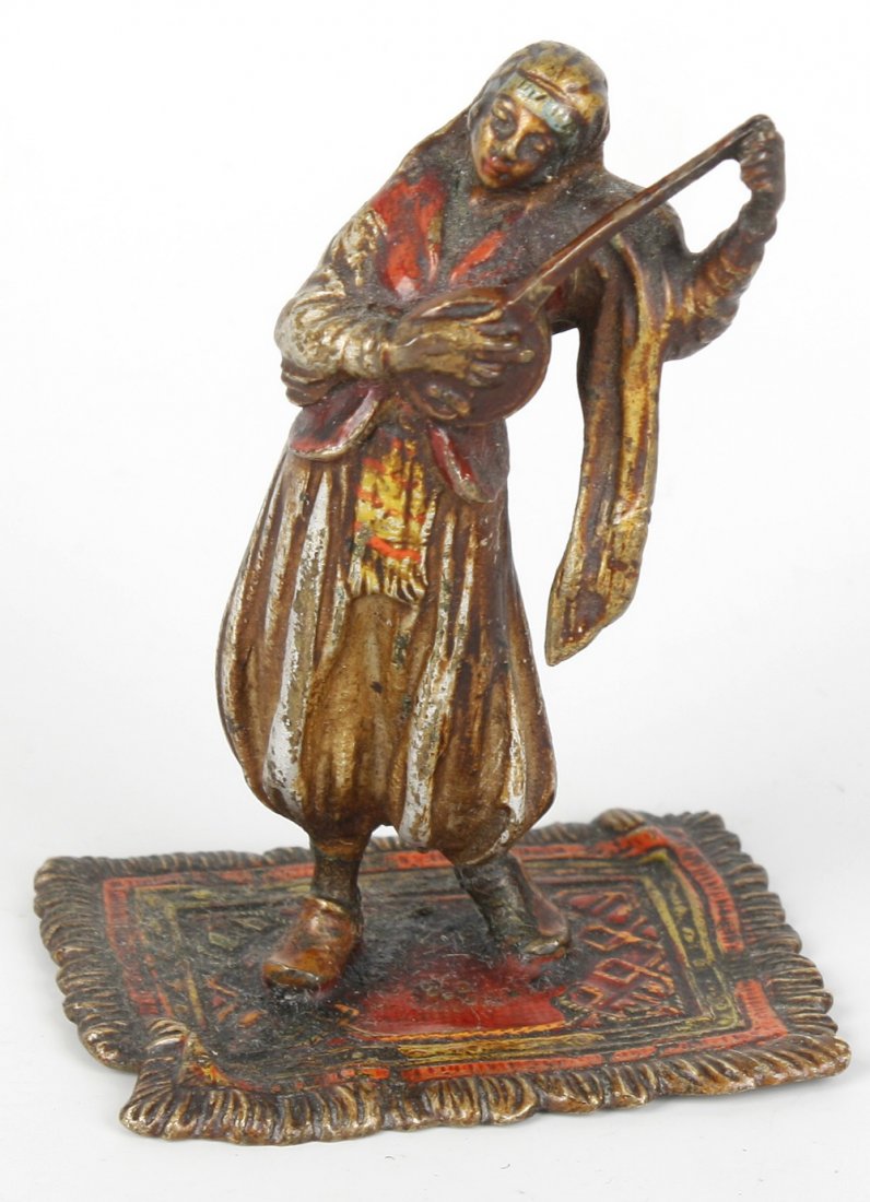 An Austrian cold painted bronze figure: An Austrian cold painted bronze figure, in the manner of Franz Bergman, modelled as an Arabian female musician, playing a sitar or similar, standing upon an Eastern rug, 3.5" (9cm) high.