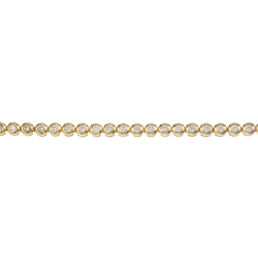 An 18ct gold diamond line bracelet.: An 18ct gold diamond line bracelet. Designed as a series of brilliant-cut diamond collets, to the partially concealed clasp. Estimated total diamond weight 1.10cts. Hallmarks for Edinburgh. Length 18.