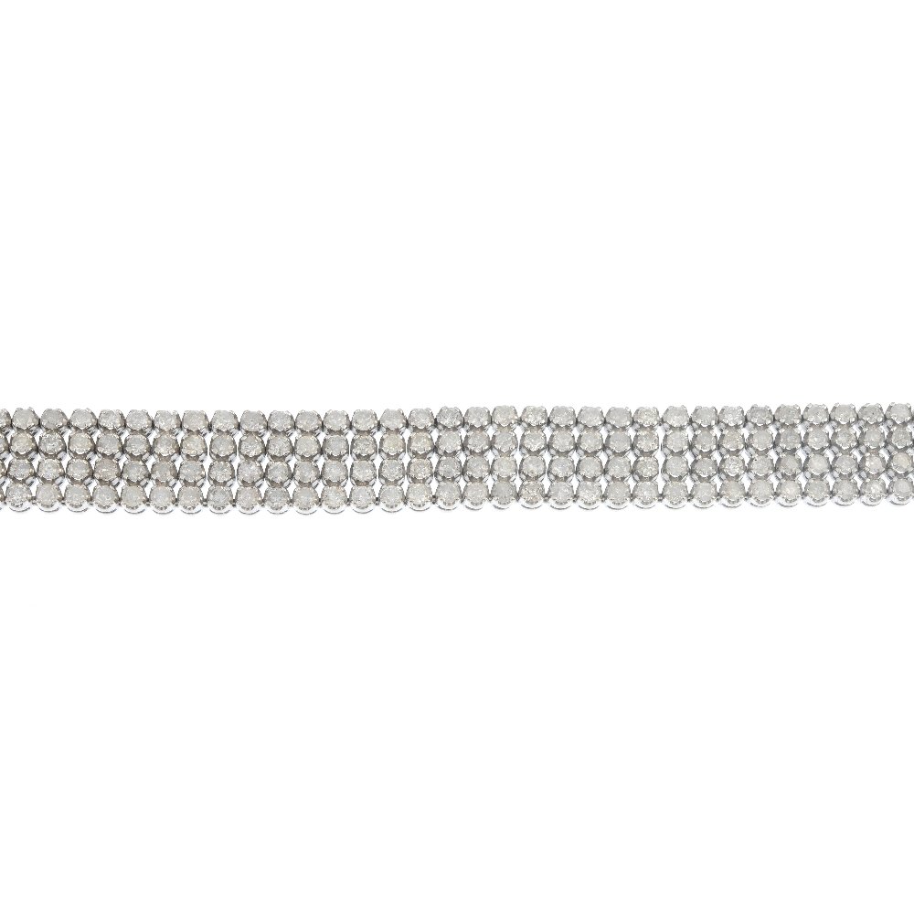A diamond bracelet.: A diamond line bracelet. Designed as a brilliant-cut diamond collet panel, to the partially concealed clasp. Estimated total diamond weight 9cts. Length 18cms. Weight 28.1gms.
