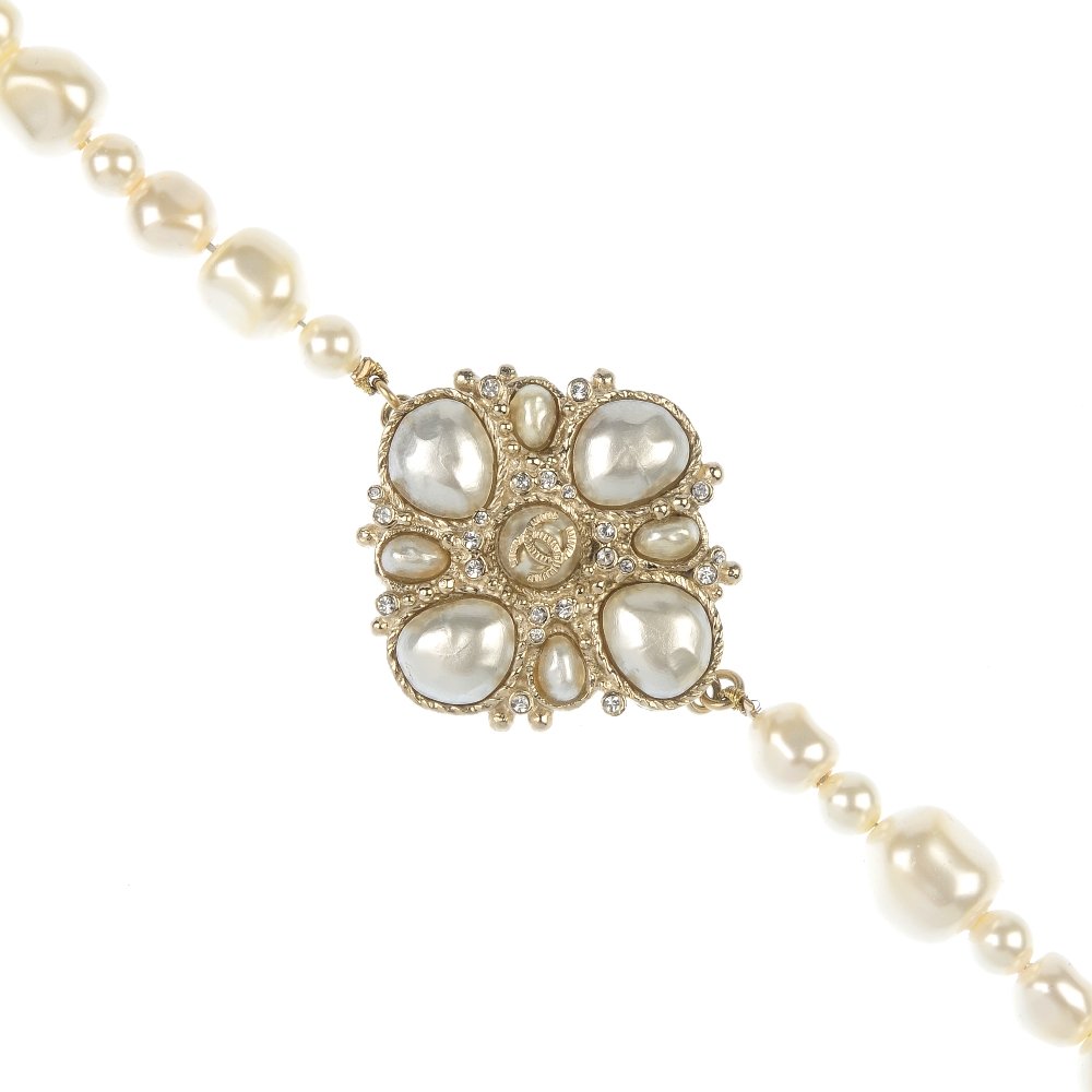 CHANEL -an imitation pearl necklace.: CHANEL - an imitation pearl necklace, the front designed as an imitation pearl and colourless paste panel, to the irregularly-shaped imitation pearl double-row, with Chanel monogram spacers. Signed Ch