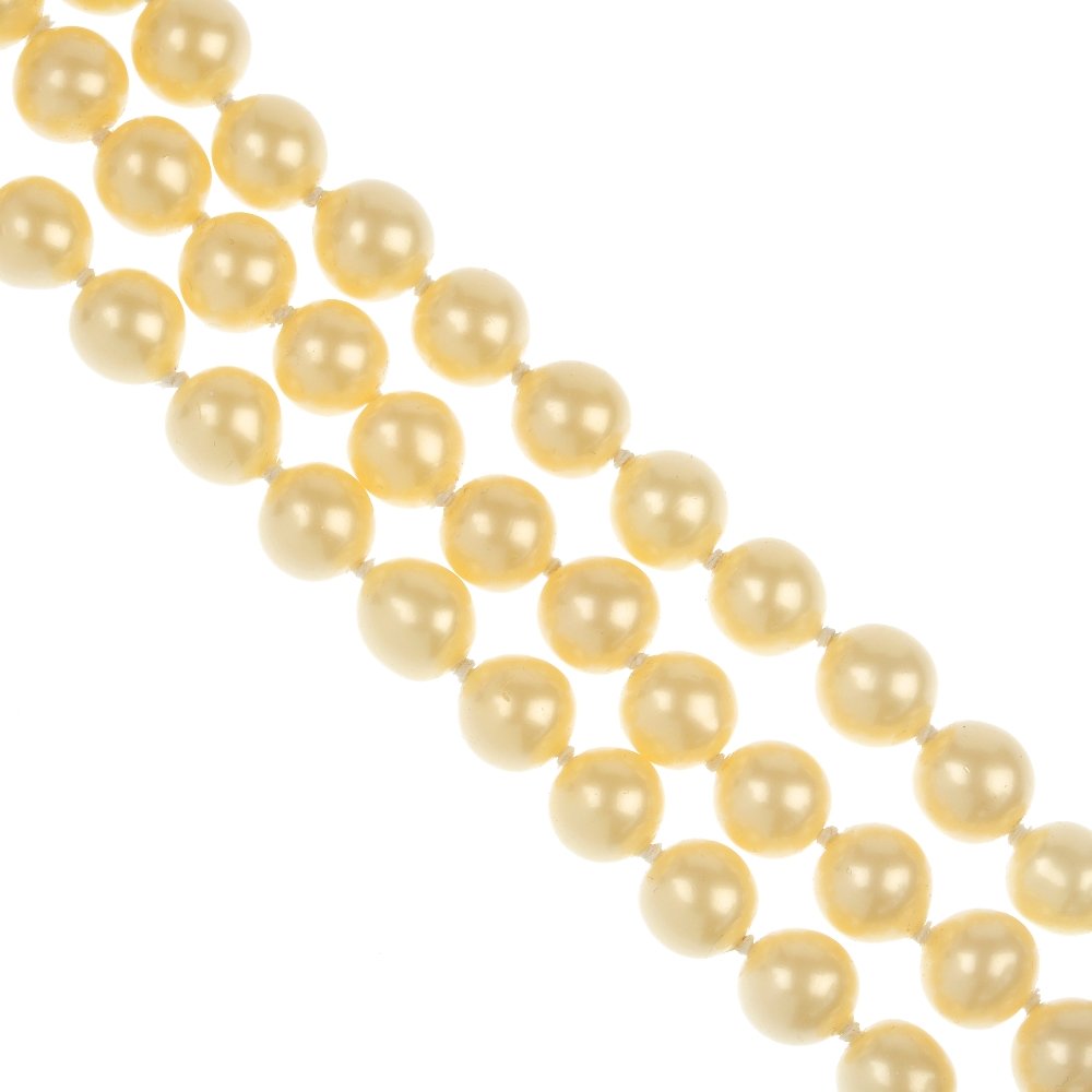 CHANEL - an imitation pearl three-row choker.: CHANEL - an imitation pearl three-row choker, designed as a series of three rows of twenty-three imitation pearls, measuring 12mms, to the hook and bar clasp. Signed Chanel. Length 33cms.