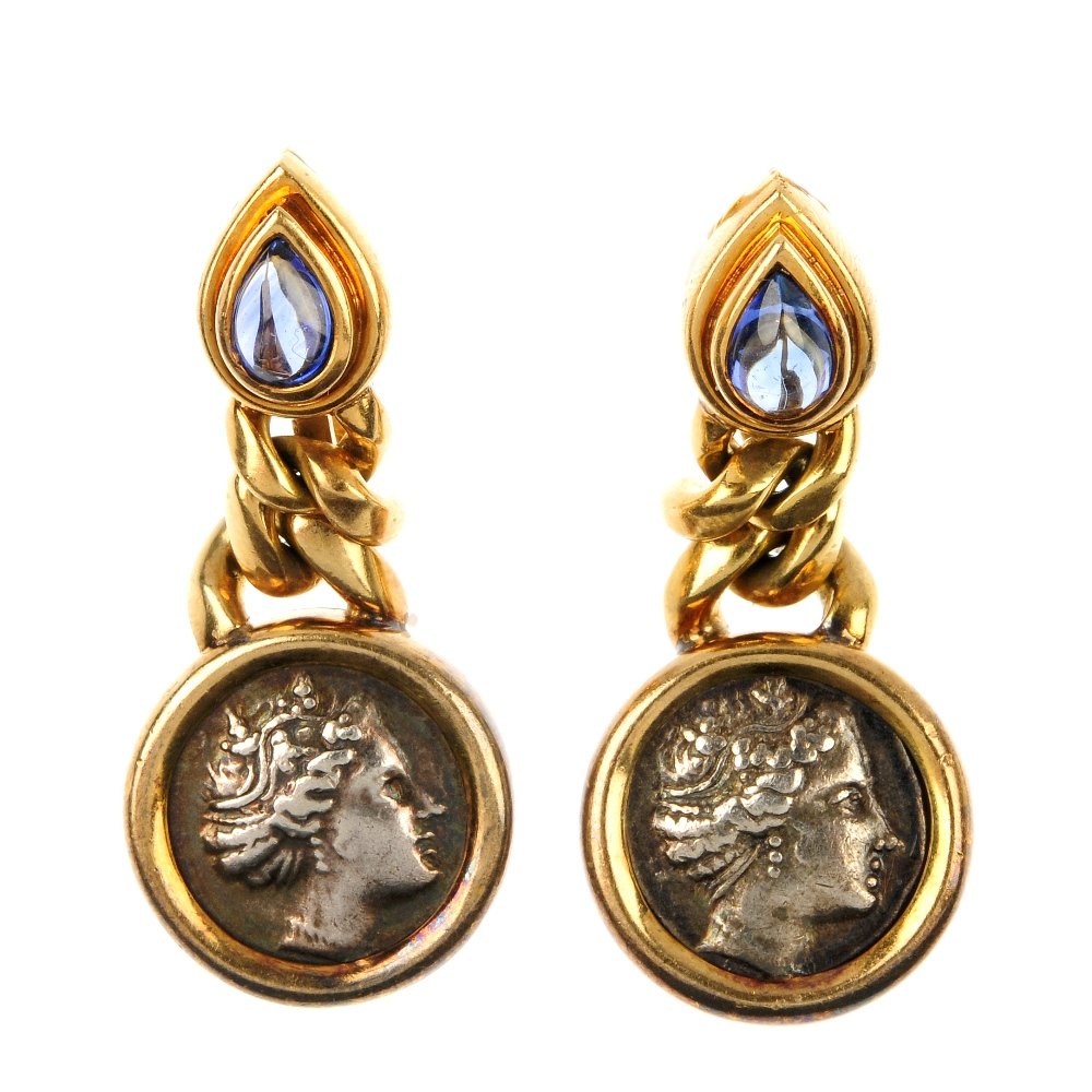 BULGARI - a pair of gem-set coin ear clips.: BULGARI - a pair of gem-set coin ear clips. Each designed as a mounted coin, depicting Histiaea in profile, to the curb-links, suspended from a pear-shape sapphire cabochon collet surmount. Signed Bul