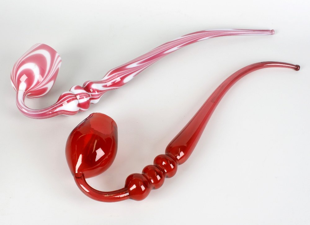 Two late Victorian glass novelty 'frigger' pipes: Two late Victorian glass novelty 'frigger' pipes. The first of 'Nailsea' type with pink and white festoons, 19.5", (49.5cm) high, the second cranberry glass, 18", (46cm), (2).
