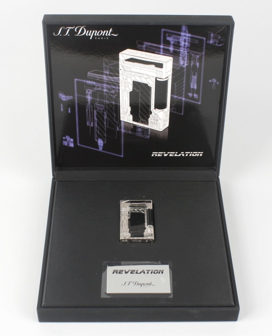 An S.T. Dupont limited edition Revelation lighter: An S.T. Dupont limited edition Revelation lighter, with guilloche-engraved and palladium finished body, hinged lid, and black lacquer and silver powder finished detail, stamped 'S.T. Dupont Paris Made