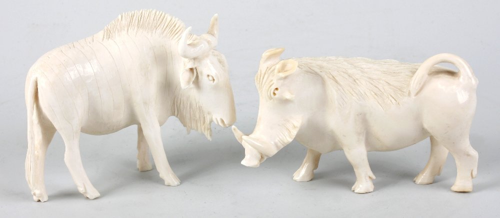 Two carved ivory animals: Two carved ivory animals, modelled as a warthog or wild boar and a bison respectively, the first 4" (10cm) long. (2).