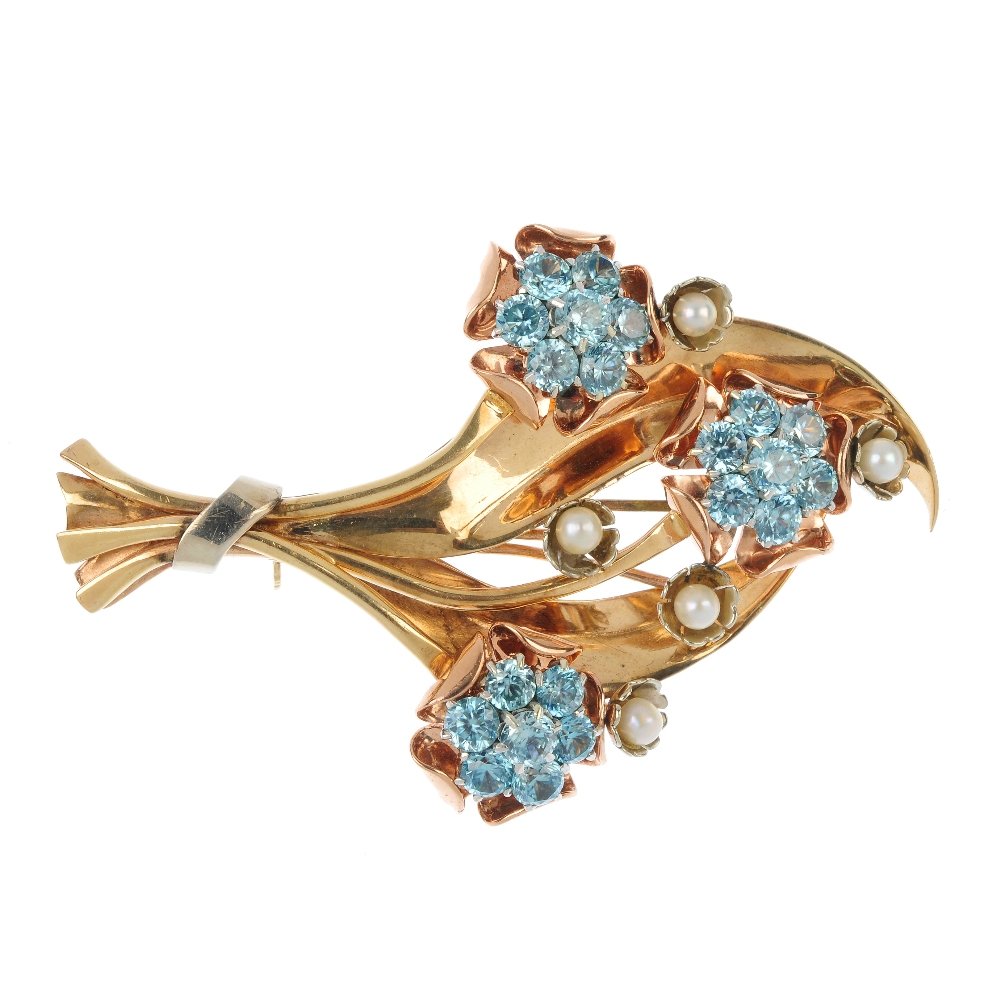 A mid 20th century zircon and cultured pearl spray: A mid 20th century zircon and cultured pearl spray brooch. Of bi-colour design, the circular-shape blue zircon floral clusters and cultured pearl bud accents, gathered by ribbon detail. Length 6.8cms.