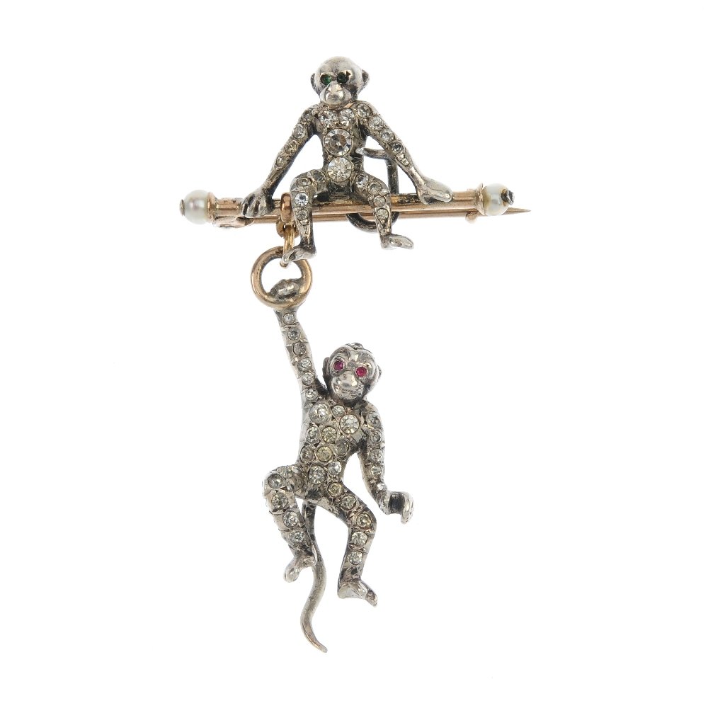 An early 20th century silver and gold paste monkey: An early 20th century silver and gold paste monkey brooch, designed as a colourless paste silver monkey sitting atop a seed pearl terminal bar, suspending a further similarly-set paste monkey. Length