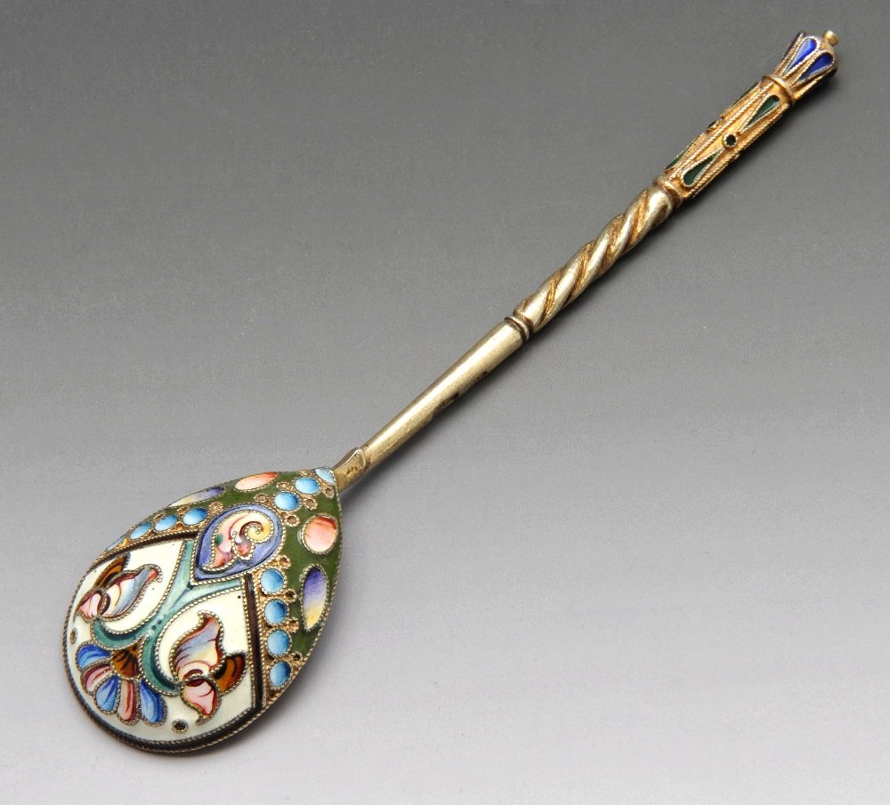 A turn of the century Russian silver-gilt and cloisonne: An early twentieth century Russian silver-gilt and cloisonné enamel coffee spoon, the teardrop bowl enamelled to the reverse with a stylised floral and beaded motif in shades of red, blue, green and